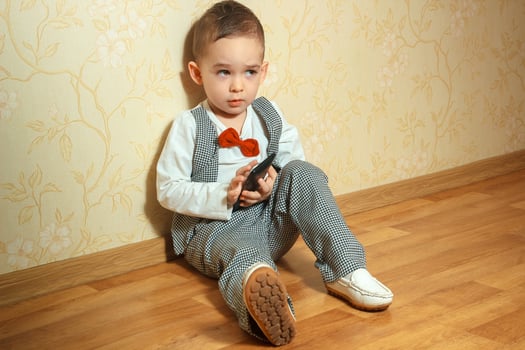 boy sits on the floor in elegant suit photo