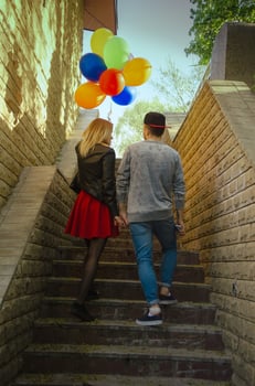 couple walks outdoors with balloons photo