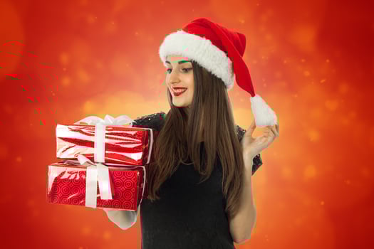 Glamour girl in santa hat with red gift box photo