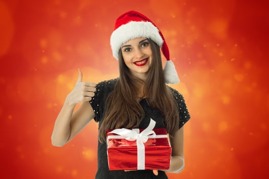 girl smiling in santa hat with red gift photo