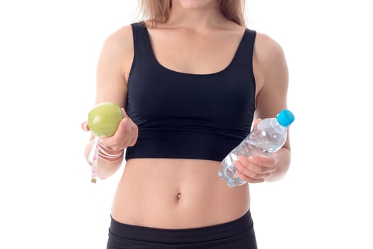 lose-up of a young girl who shows her an apple and water photo