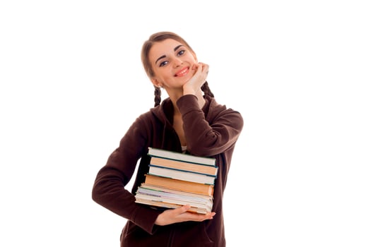 young beautiful student girl with a lot of books in her hands posing isolated on white background in studio photo