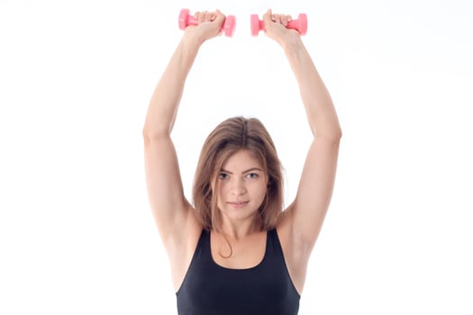 athletic woman is holding up two hands with dumbbells photo