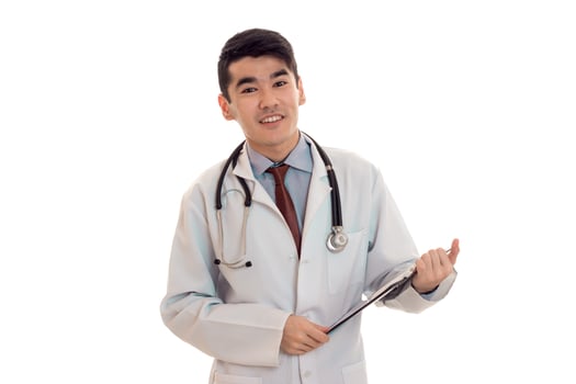 young cheerful male doctor with stethoscope in uniform isolated on white background photo