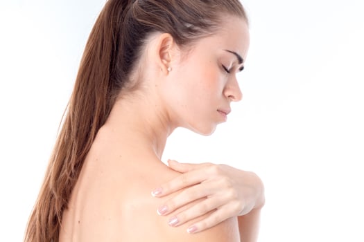 young girl is worth turning sideways and keeps  hand on the shoulder  isolated   white background photo