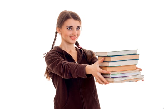 cheerful young student girl with books in brown sport clothes smiling isolated on white background. student years concept. study concept. photo