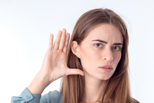 young girl looks forward and holds his hand near the ear close-up photo