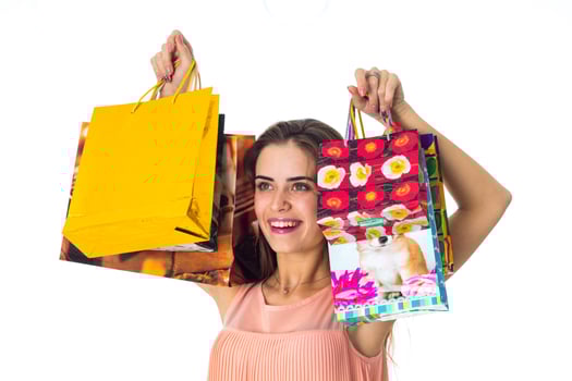 cheerful young girl raised up in front of  large colored packets with gifts close- photo