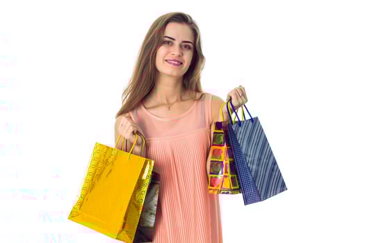 young girl stands up straight and keeps on hand  bright bags isolated  white background photo