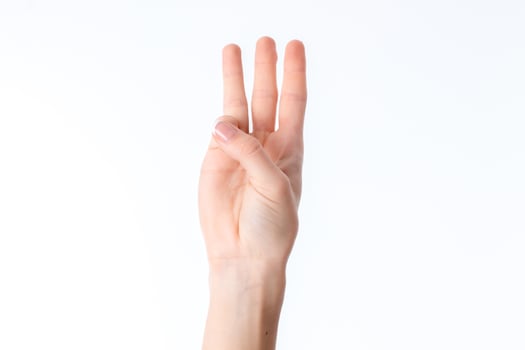 female hand stretched up and showing three fingers isolated on white background photo
