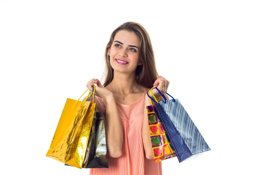 joyful girl looks away and holds color shopping bags isolated on white background photo