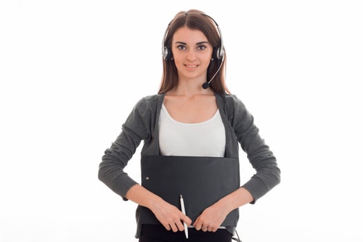 beautiful young girl in headphones and gray jacket looks into the camera and smiles holding Tablet photo