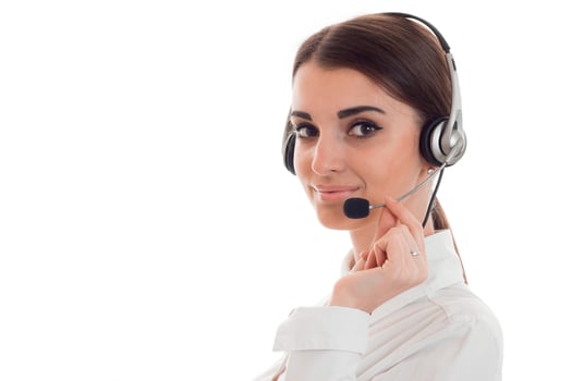 beautiful young brunette business woman with headphones and microphone smiling isolated on white background photo