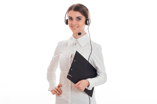 cheerful young brunette business woman with headphones and microphone posing isolated on white background photo