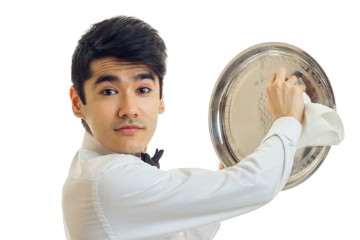 Portrait of a handsome young waiter that looks into the camera and side tray cloth close-up photo