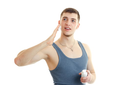 funny young guy in the gray shirt looks into the distance smiling and causes the foam to your face photo
