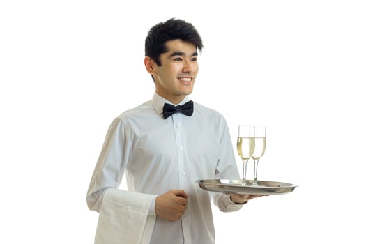 smiling handsome waiter with black hair and shirt holding a tray with two glasses of wine photo