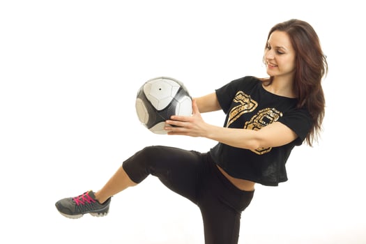 young cheerful sportswoman in black kicks a soccer ball kicked photo