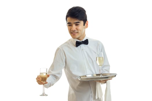 fine young waiter looks sideways smiles and takes a glass of wine with a tray photo