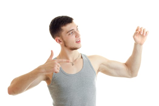 handsome young guy in the t-shirt looks away and shows hands gestures photo