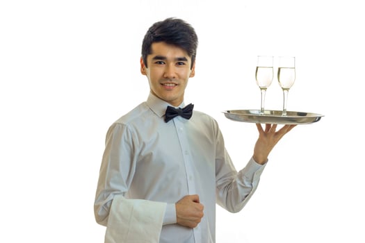 attractive young waiter raised his hand tray with two glasses and smiling photo