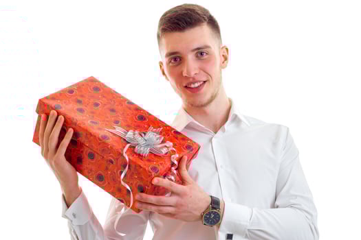 wonderful young guy in shirt smiling and holding a gift close-up photo