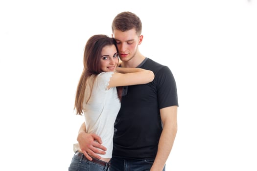 cute young brunette snuggled to the guy and he's hugging isolated on a white background photo
