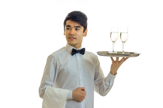 attractive young waiter in a shirt raised in hand a tray with glasses photo