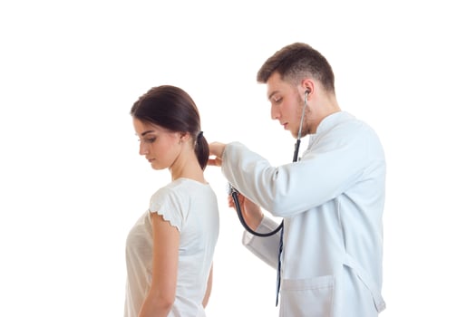 doctor with stethoscope examines a woman patient photo