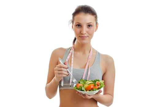 Portrait of a beautiful young girl with a vegetable salad in the hands photo