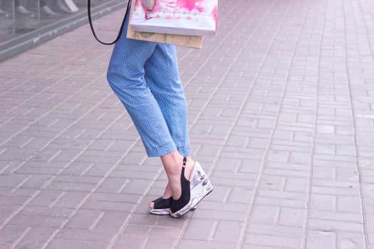 elegant woman on high heels with shopping bags in hands photo