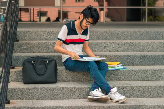 handsome guy sitting on the street and reads books photo