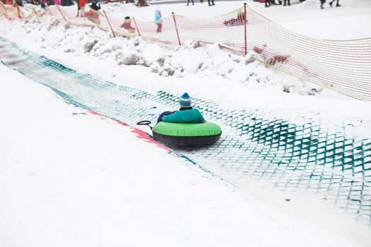 Child having fun on snow tube. Boy is riding a tubing. Winter entertainment. kid sliding downhill on tube photo