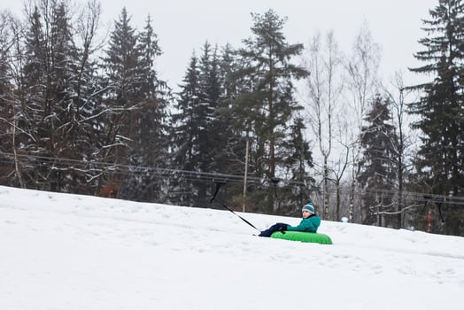 Child having fun on snow tube. Boy is riding a tubing. Winter entertainment. kid sliding downhill on tube. ride a lift photo
