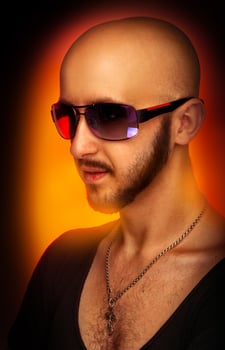 Caucasian male in sunglasses looking away in studio photo