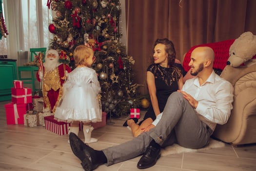 horizontal photo of Cheerful family with daughter celebrate New year and Christmas together at home