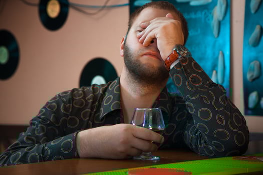 horizontal Photo of Drunk man with a glass of brandy at the bar