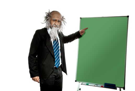 bald old teacher points on blackboard photo