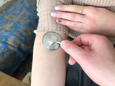 The doctor holds in his hand a medical stethoscope, phonendoscope and listens to the pulse, measures the pressure on the hand of a beautiful girl, a woman photo