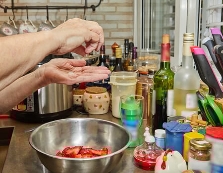 Chef salts sliced strawberries for dessert in the home kitchen photo