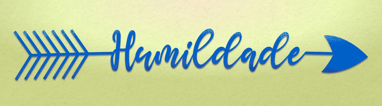 Blue arrow with the word humility in Brazilian Portuguese on light green wall. Translation - Humility. photo