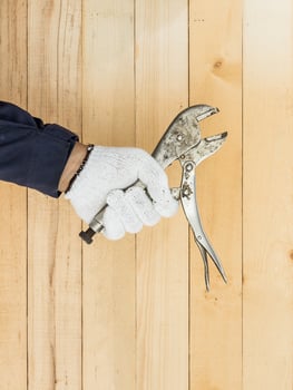 Hand in glove holding Adjustable wrench photo