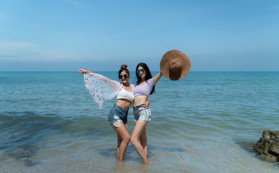 LGBT couples traveling around Asia, Swim happily on the sandy beach with the beautiful blue sea photo