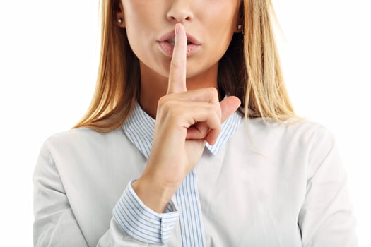 Adult woman holding a finger on her lips over white background photo