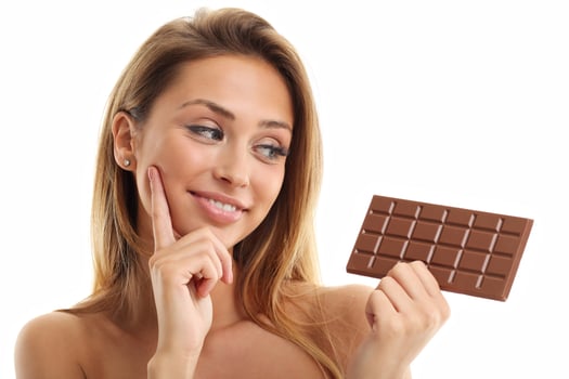 Portrait of beautiful woman holding chocolate bar photo