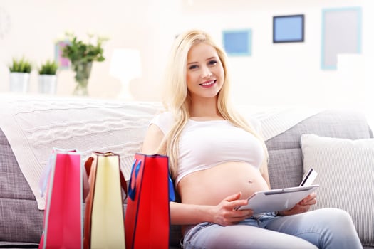 Pregnant woman using tablet for online shopping at home photo