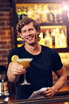 Handsome bartender serving cocktails in a pub photo