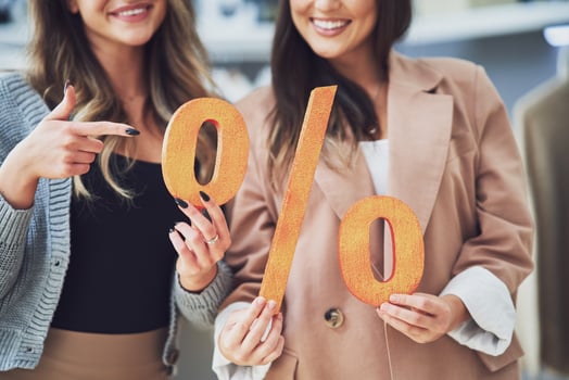 Two girls on shopping holding sale percentage sign. photo