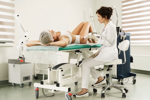 Doctor and woman client during radio frequency skin resurfacing treatment for stretching marks removal photo