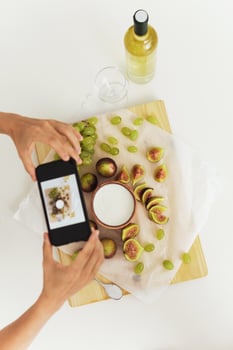 Woman taking photo  of her delicious Greek yogurt with figs by her smartphone